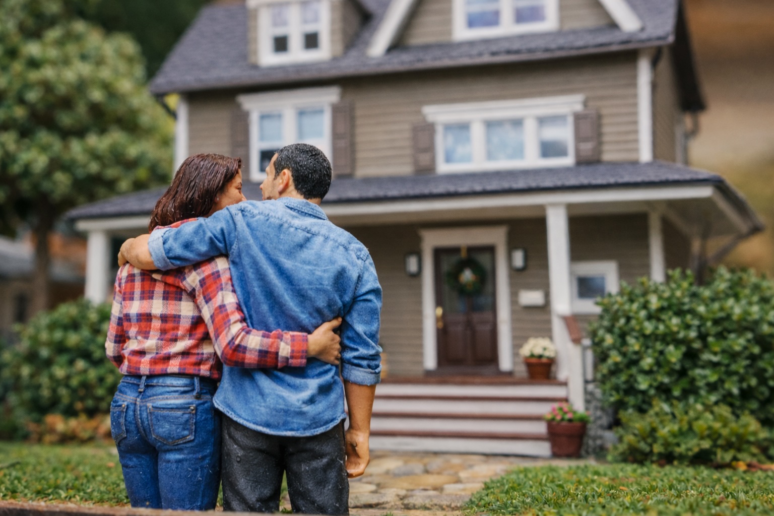 A new homeowner standing at the front door of their house, keys in hand
